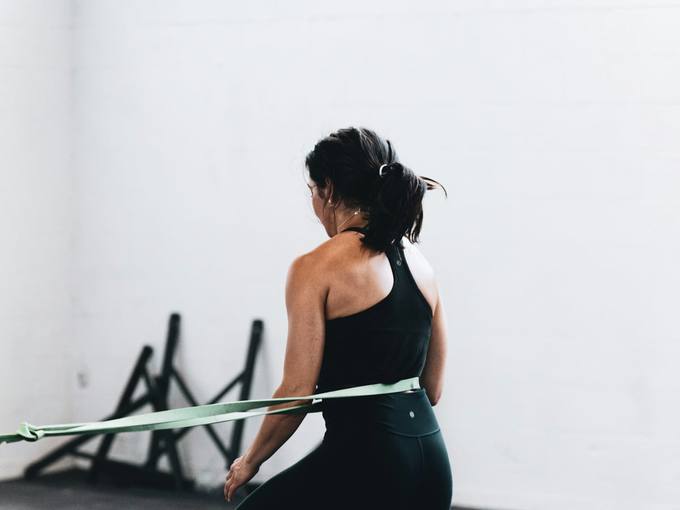 A woman doing a lunge with a resistance band