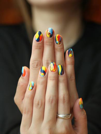 Nails painted in bright primary colour stripes
