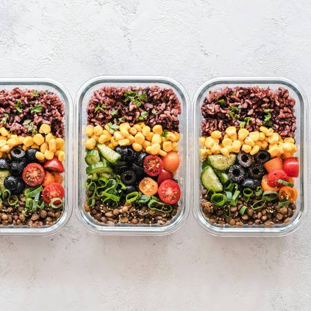Three meal prep boxes with grains, chickpeas and salad