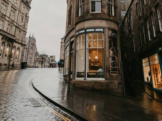 A rainy New Town street corner with Georgian stone buildings