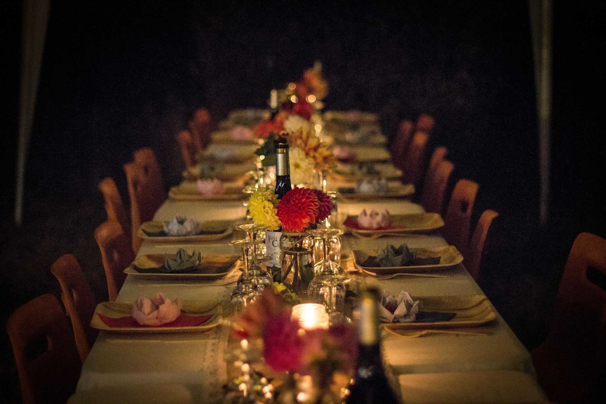 A long candlelit table set for a party