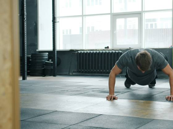 A coach crouching to check a client's push-up form