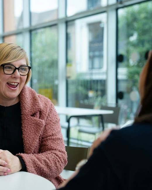 A recruiter laughing during a meeting with a client