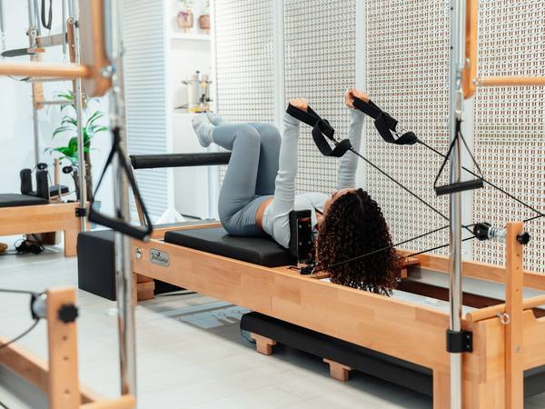 A patient exercising on a Pilates reformer