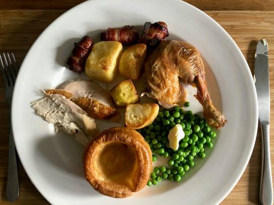 Roast chicken with a Yorkshire pudding, peas and roast potatoes