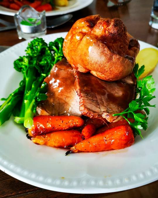 Roast beef with a Yorkshire pudding, carrots and greens