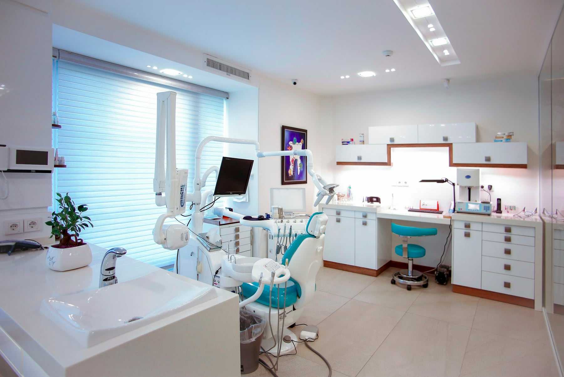 A bright treatment room with a dental chair and cabinets