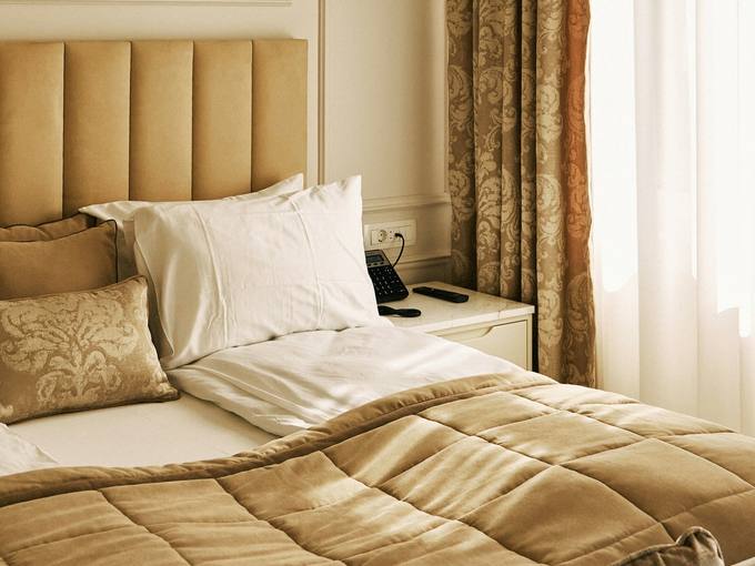 A soft bedroom with long curtains and an upholstered headboard