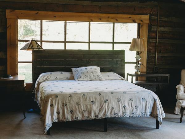 A bedroom with an iron bed and a wide window