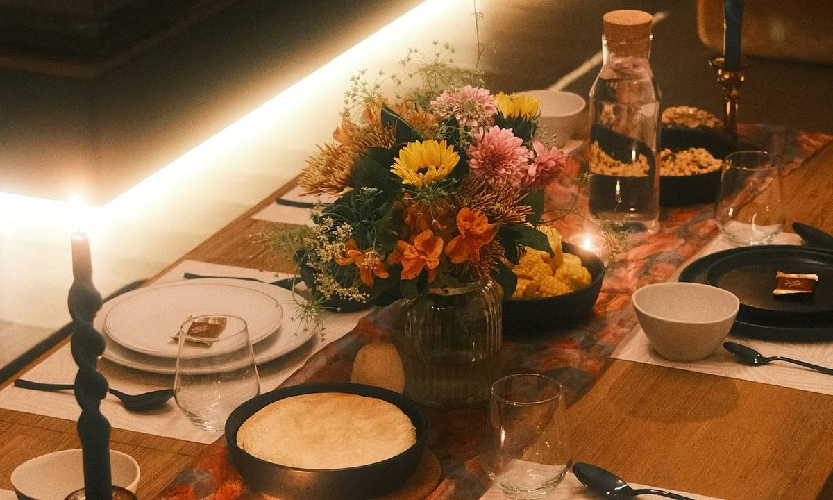A long table laid with candles and plates