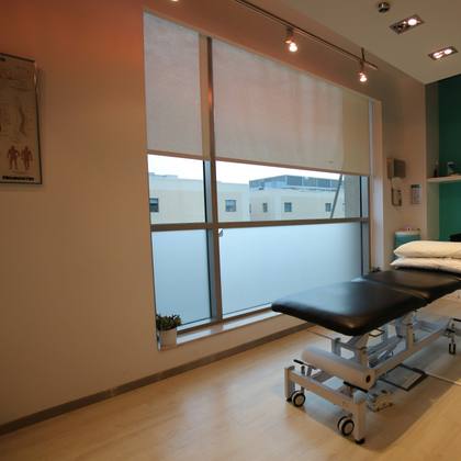 A bright treatment room with a couch and equipment
