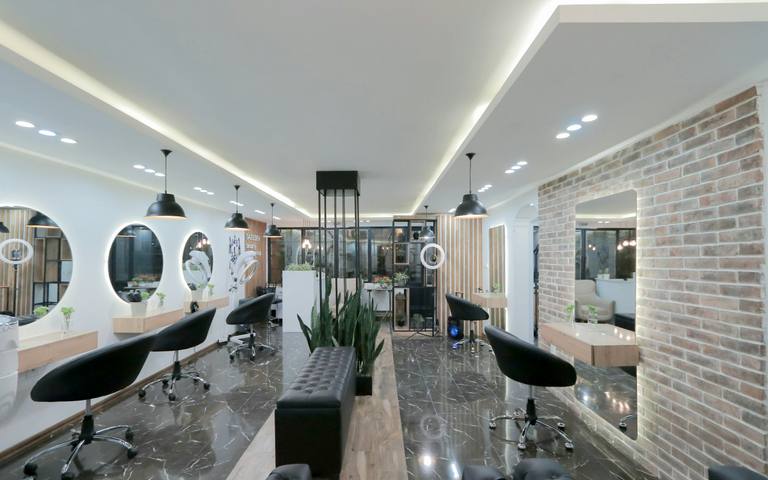 The bright salon with round mirrors and black chairs