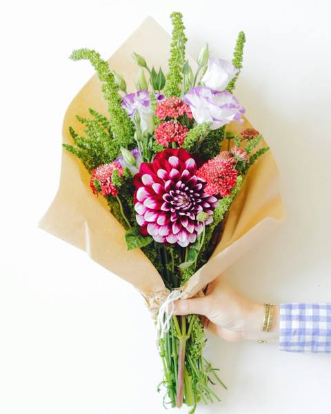 A loose seasonal bouquet wrapped in kraft paper