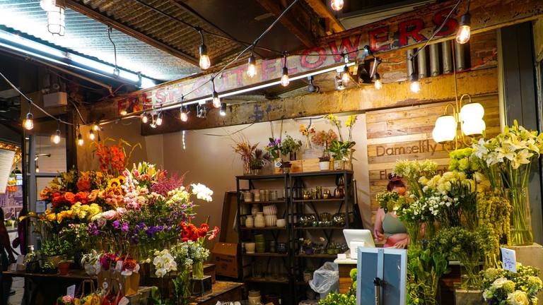 Inside the flower studio, full of buckets of flowers and warm lights