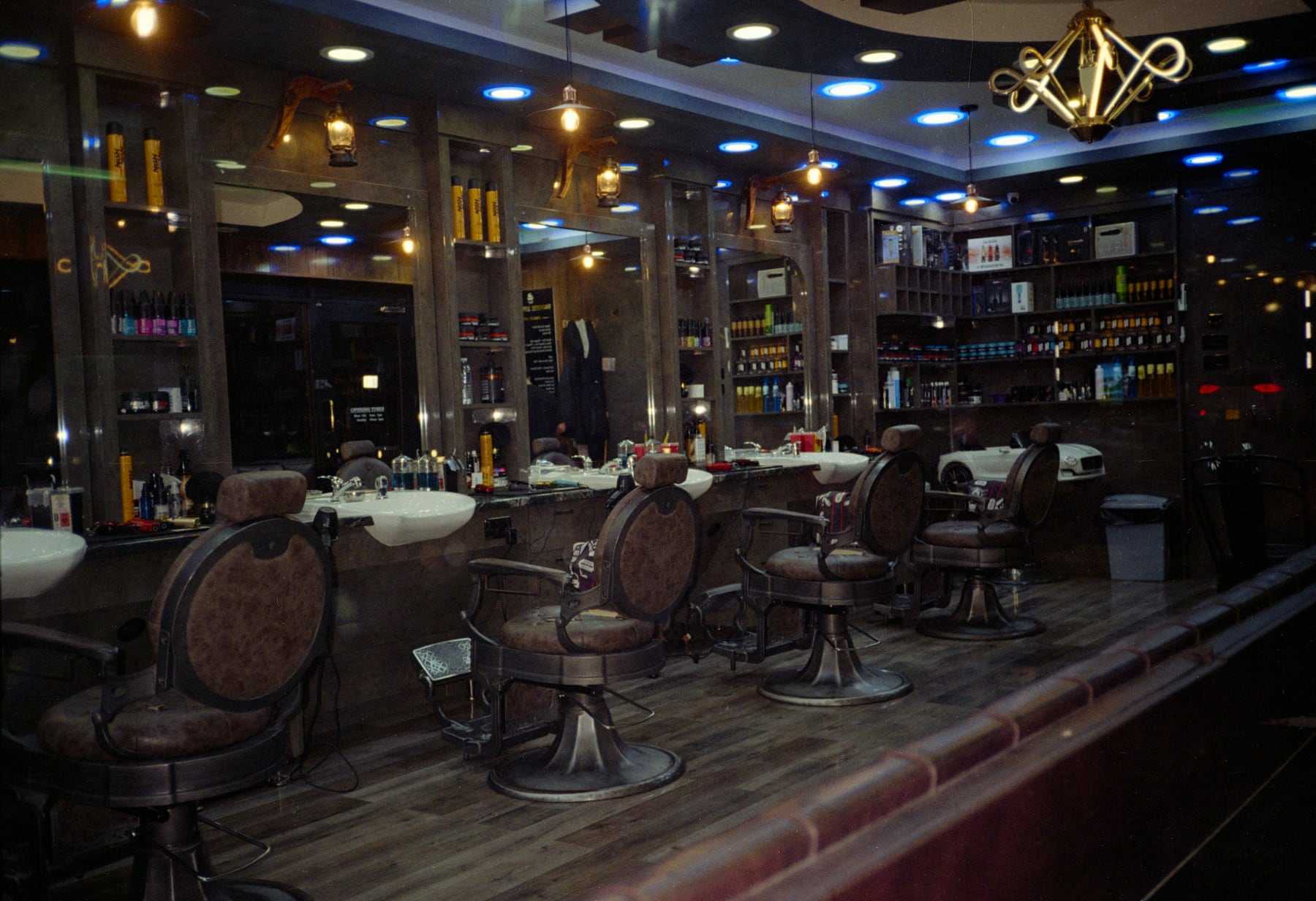 Inside the shop: leather chairs, mirrors and warm lights