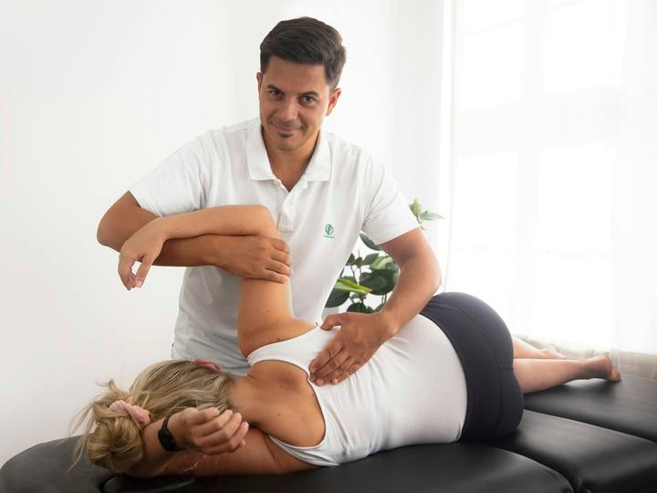 A physiotherapist mobilising a patient’s shoulder