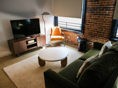 The suite lounge with a green sofa and a brick wall