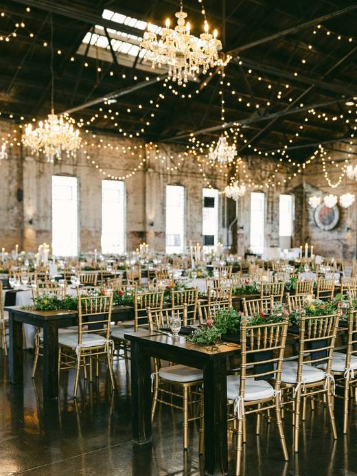 Long tables under strings of lights in the barn