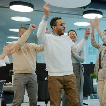 A team celebrating with high fives in a bright office