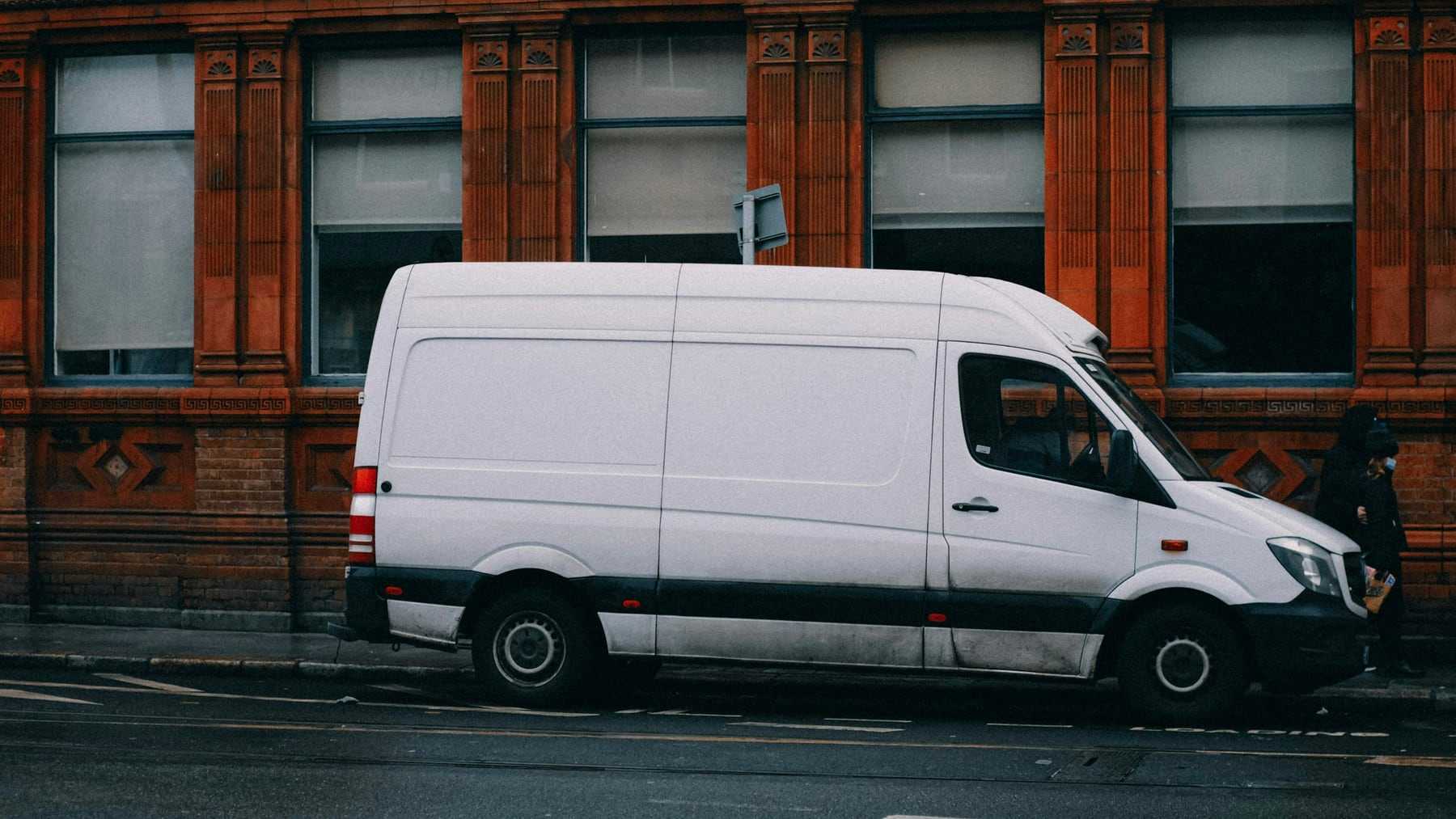 A white Tapgrove van parked outside a red brick building