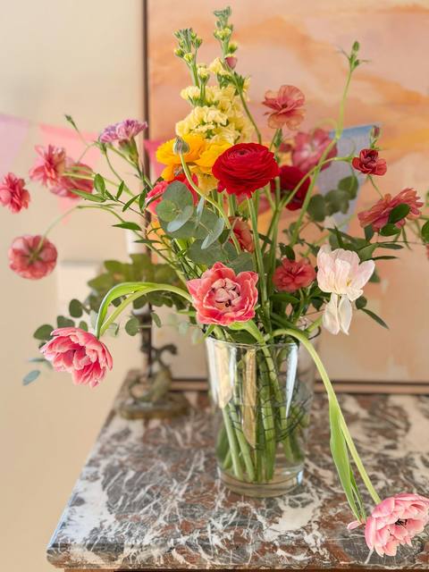 A bright arrangement of seasonal flowers in a glass vase