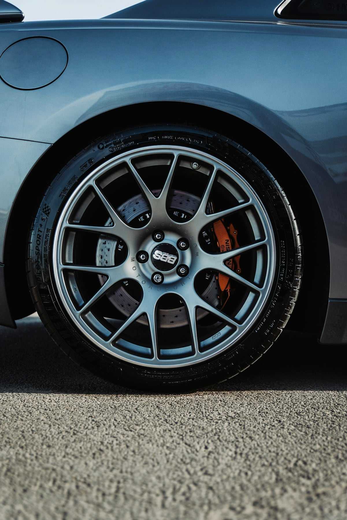 A grey alloy wheel on a car parked outside the workshop