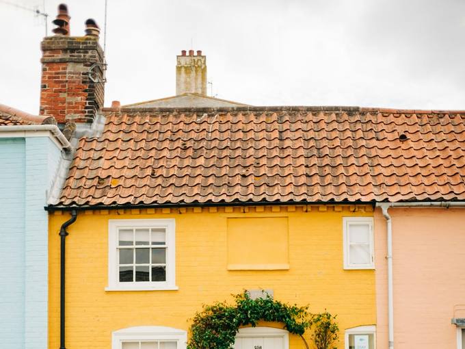 The yellow-painted cottage with a white picket fence